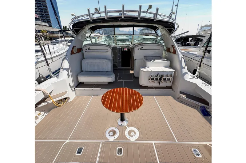 Slide: The Image of 1997 Sea Ray 370 Express Cruiser interior with seating and table, docked at marina. - 15