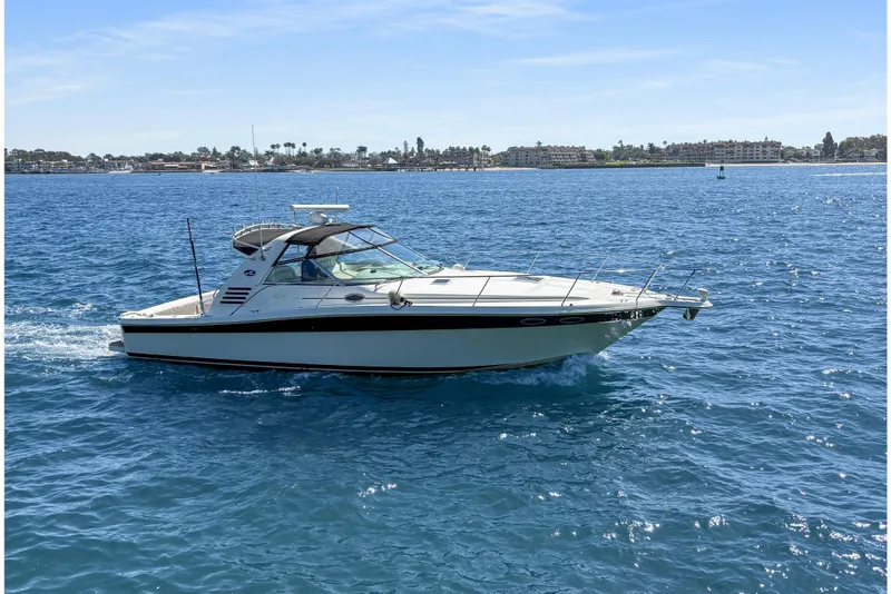 Slide: The Image of 1997 Sea Ray 370 Express Cruiser on open water under clear blue sky. - 7