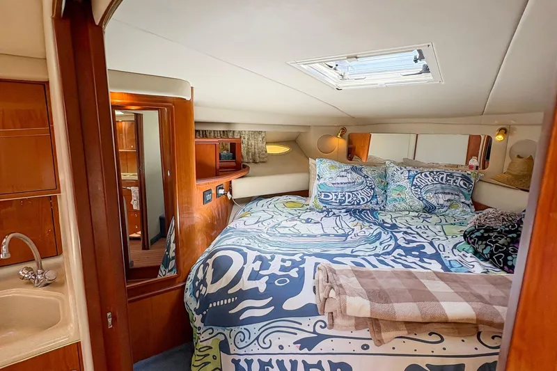 Slide: The Image of 1997 Sea Ray 370 Express Cruiser cabin with cozy bed and nautical decor. - 24
