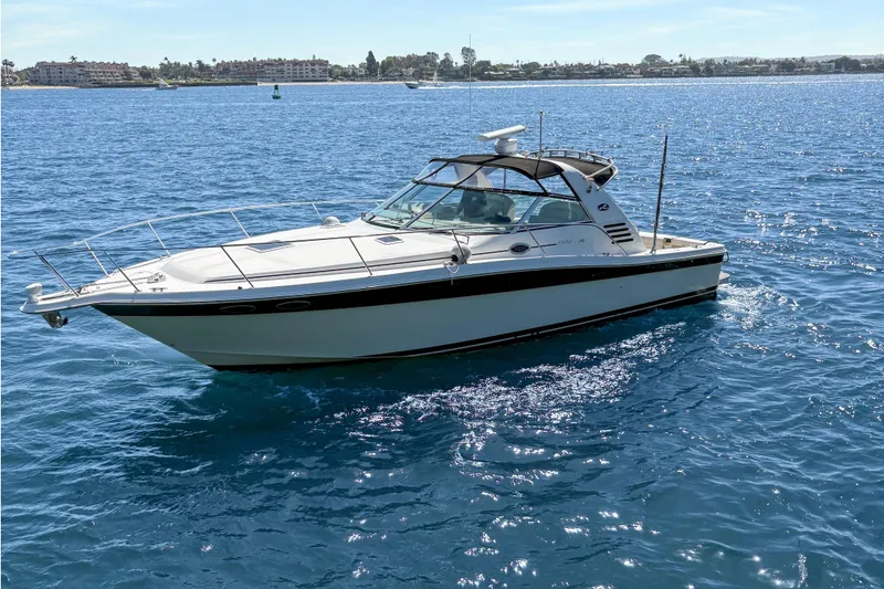 Slide: The Image of 1997 Sea Ray 370 Express Cruiser on calm blue water under clear sky. - 5