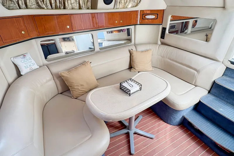 Slide: The Image of Interior of 1997 Sea Ray 370 Express Cruiser with plush seating and wooden cabinetry. - 22
