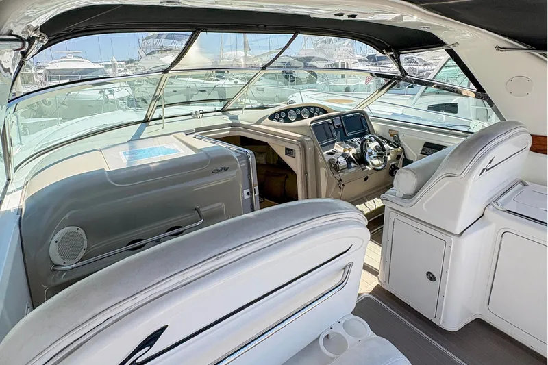 Slide: The Image of 1997 Sea Ray 370 Express Cruiser cockpit with white seating and modern dashboard controls. - 16