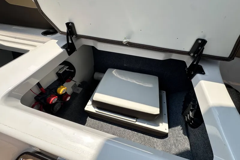Slide: The Image of Open storage compartment in 2023 Yamaha Boats 252SE, showcasing interior components and wiring. - 17