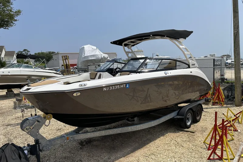 Slide: The Image of 2023 Yamaha Boats 252SE on trailer, parked in a marina lot. - 4