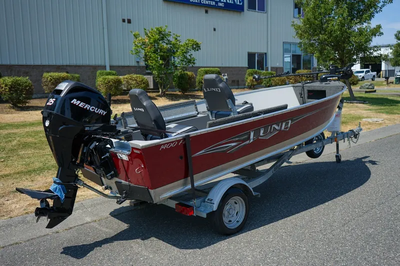 Slide: The Image of 2015 Lund 1400 Fury SS boat with Mercury engine on trailer, parked outdoors. - 3