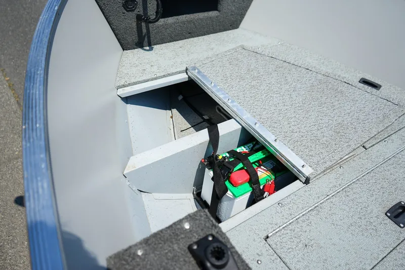 Slide: The Image of 2015 Lund 1400 Fury SS boat interior with open storage compartment and battery. - 12