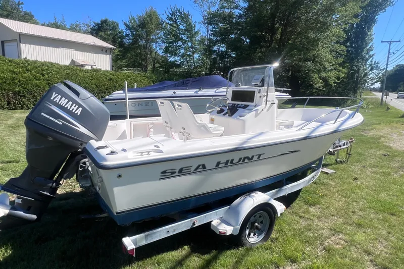 Slide: The Image of 2004 Sea Hunt Triton 177 boat with Yamaha outboard motor on trailer, parked on grass. - 3