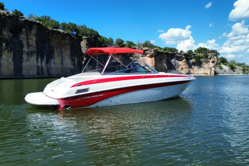 Slide: The Image of 2016 Crownline 275 SS boat with red canopy on a scenic lake. - 10