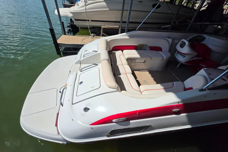 Slide: The Image of 2016 Crownline 275 SS boat with spacious seating and sleek design docked on water. - 20