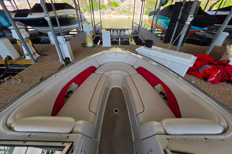 Slide: The Image of 2016 Crownline 275 SS boat interior with red and white seating in a docked setting. - 29
