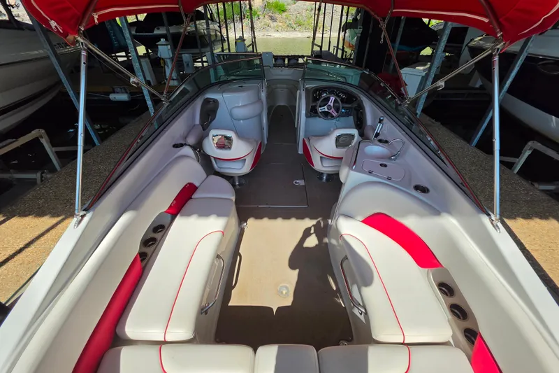 Slide: The Image of 2016 Crownline 275 SS boat interior with red and white seating under a canopy. - 27