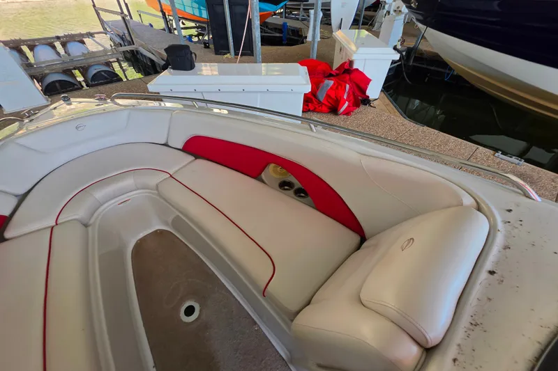 Slide: The Image of 2016 Crownline 275 SS boat interior with red and white seating at a dock. - 31