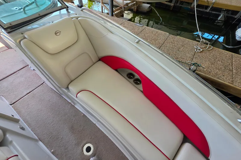 Slide: The Image of 2016 Crownline 275 SS boat interior with white and red seating, docked by the water. - 32