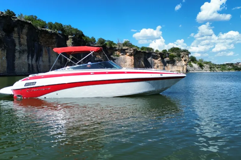 Slide: The Image of 2016 Crownline 275 SS boat with red canopy on a scenic lake. - 18