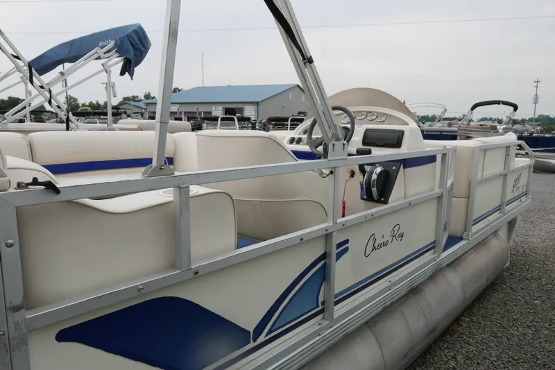 Slide: The Image of 2002 Crest 20 Sport pontoon boat with white and blue seating, docked outdoors. - 3