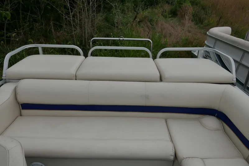 Slide: The Image of 2002 Crest 20 Sport boat with white cushioned seating, surrounded by greenery. - 12
