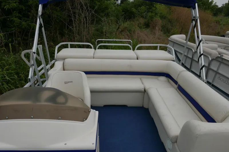 Slide: The Image of 2002 Crest 20 Sport pontoon boat with white and blue seating, surrounded by greenery. - 8
