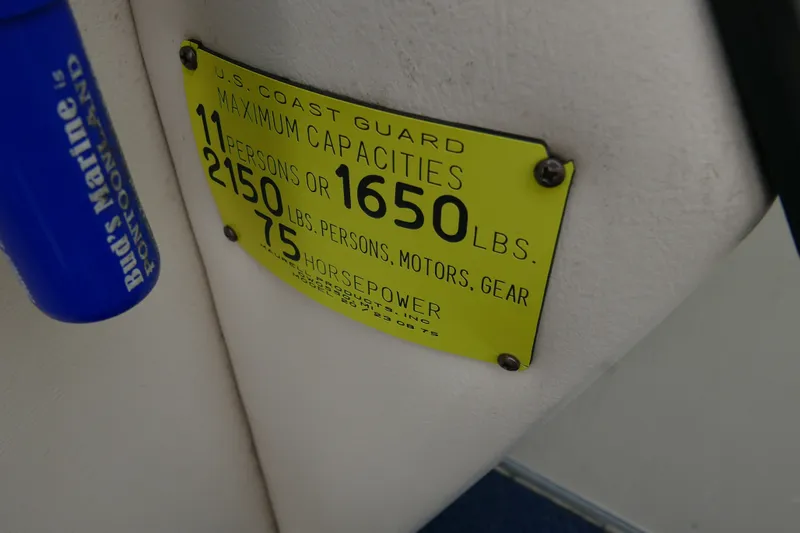 Slide: The Image of U.S. Coast Guard capacity plate on 2002 Crest 20 Sport boat, yellow with weight limits. - 13