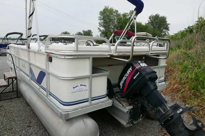 Slide: The Image of Pontoon boat, Crest 20 Sport 2002, with Mercury 60 outboard motor, parked on gravel. - 2