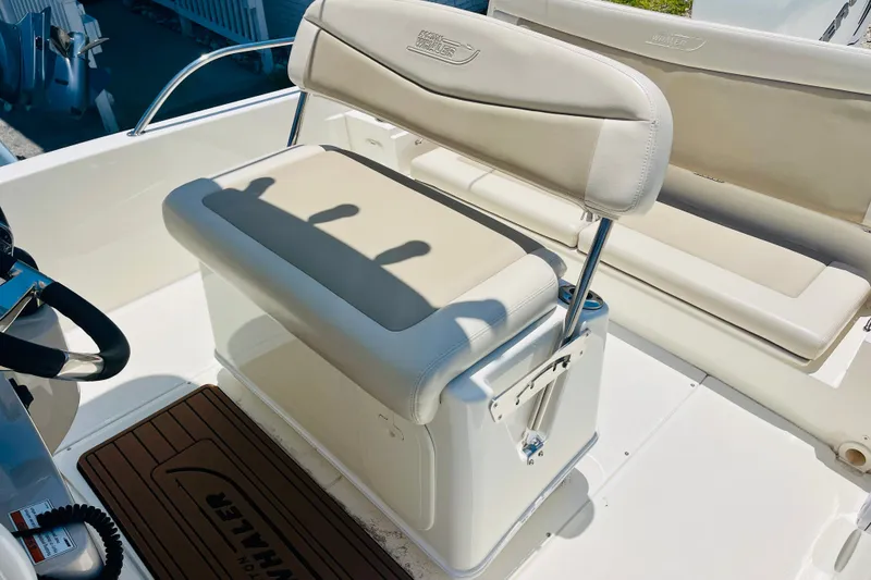 Slide: The Image of 2018 Boston Whaler 240 Dauntless boat interior with cushioned seating and steering wheel. - 14