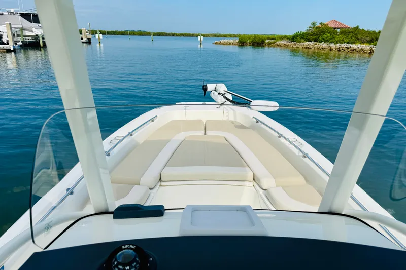 Slide: The Image of 2018 Boston Whaler 240 Dauntless boat on calm water, featuring spacious seating and clear skies. - 8