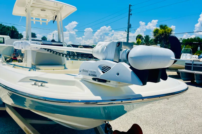 Slide: The Image of 2018 Boston Whaler 240 Dauntless boat with Minn Kota Ulterra trolling motor, docked under blue sky. - 7