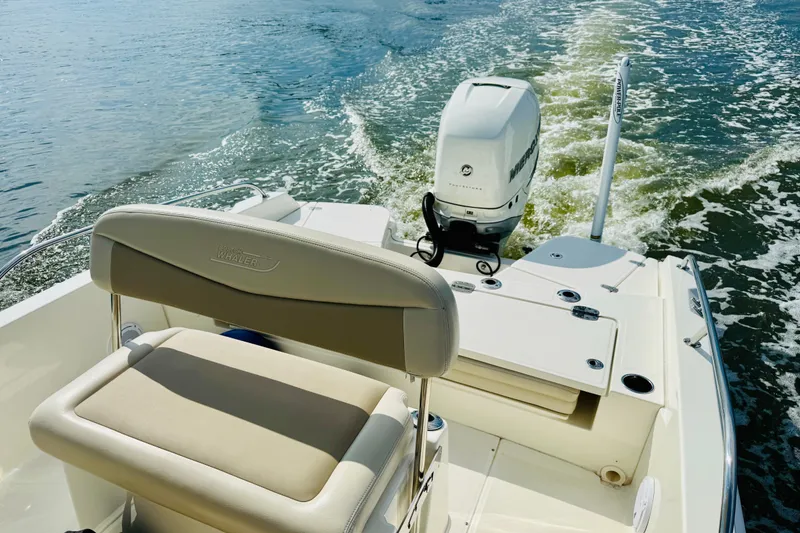 Slide: The Image of 2018 Boston Whaler 240 Dauntless boat cruising on water, rear view. - 11