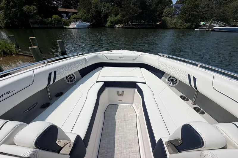 Slide: The Image of Luxurious 2027 Regal LX9 boat interior with white seating and sleek design on a calm lake. - 24