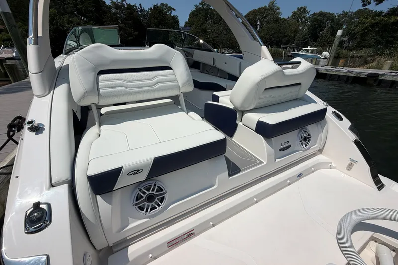 Slide: The Image of Luxurious 2027 Regal LX9 boat interior with white and navy seating, docked by the water. - 4
