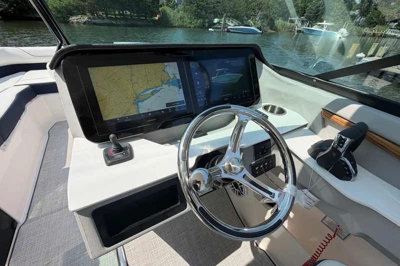 Slide: The Image of 2027 Regal LX9 boat dashboard with navigation screen and steering wheel on a sunny day. - 22