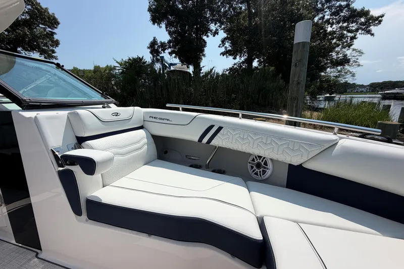 Slide: The Image of Luxurious seating on a 2027 Regal LX9 boat, featuring elegant white and navy upholstery. - 25