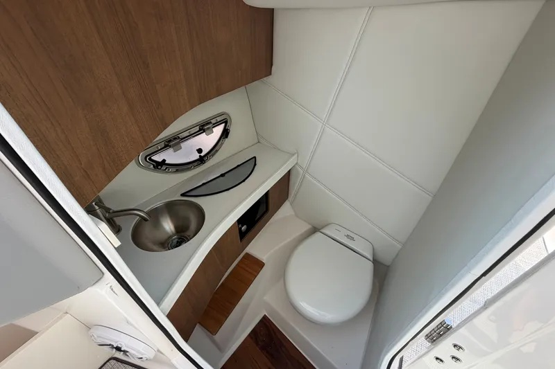 Slide: The Image of Compact bathroom in 2027 Regal LX9 boat with sink, toilet, and wooden accents. - 19