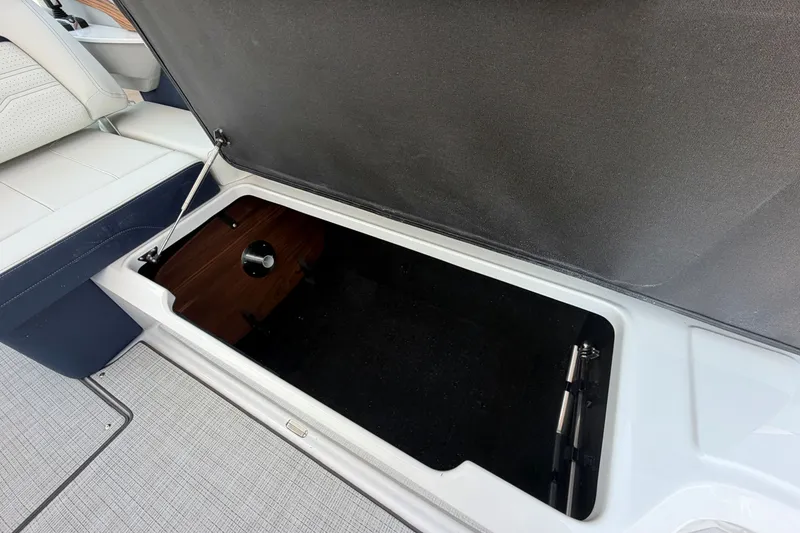 Slide: The Image of 2027 Regal LX9 boat storage compartment with open lid, showcasing spacious interior. - 10