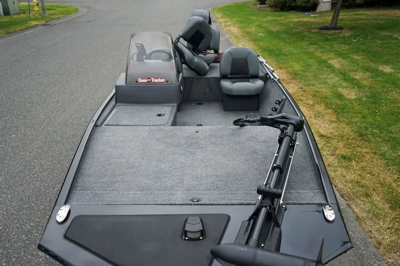 Slide: The Image of 2026 Tracker Bass Tracker Classic CC boat with seating and trolling motor on a road. - 14