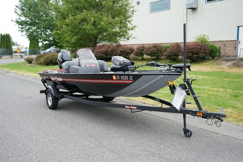 The Image of 2026 Tracker Bass Tracker Classic CC boat on trailer, parked outdoors near a building. - 1