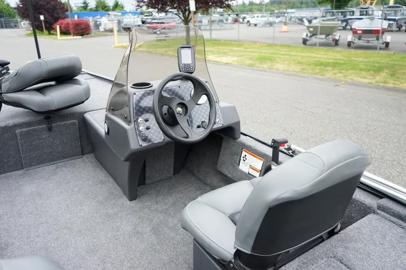 Slide: The Image of 2026 Tracker Bass Tracker Classic CC boat interior with steering console and seating. - 8