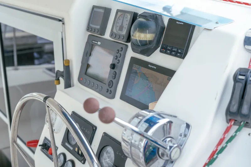 Slide: The Image of Control panel of a 2011 Leopard 38 yacht with navigation instruments and steering wheel. - 75