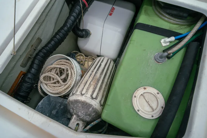 Slide: The Image of Storage compartment on a 2011 Leopard 38 boat with ropes, fender, and green tank. - 152