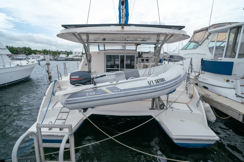 Slide: The Image of 2011 Leopard 38 catamaran with dinghy, docked at marina, featuring Yamaha motor. - 9
