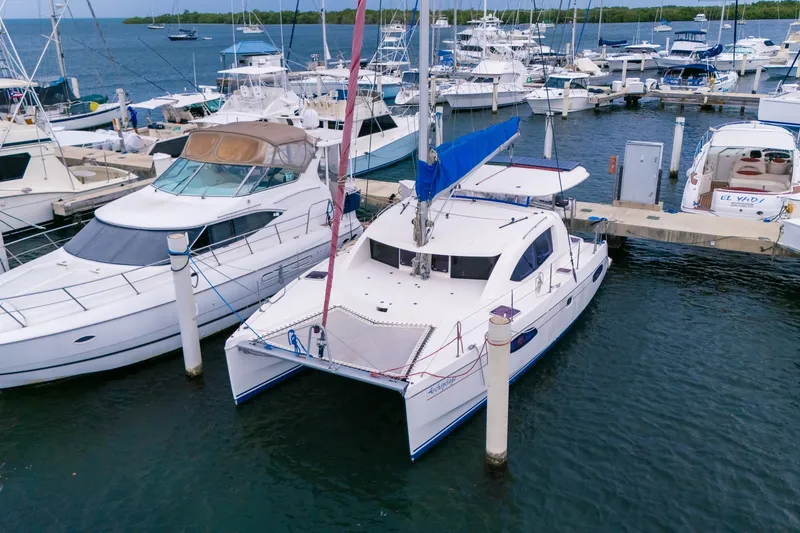 Slide: The Image of Catamaran Leopard 38, 2011 model, docked at a marina with other boats. - 2