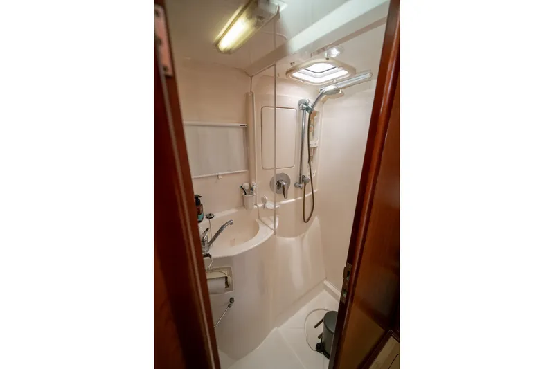 Slide: The Image of Compact bathroom in a 2011 Leopard 38 yacht, featuring a shower and sink. - 119