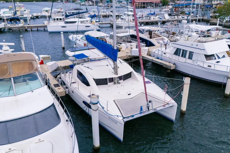 Slide: The Image of 2011 Leopard 38 catamaran docked at a marina, surrounded by various boats. - 4