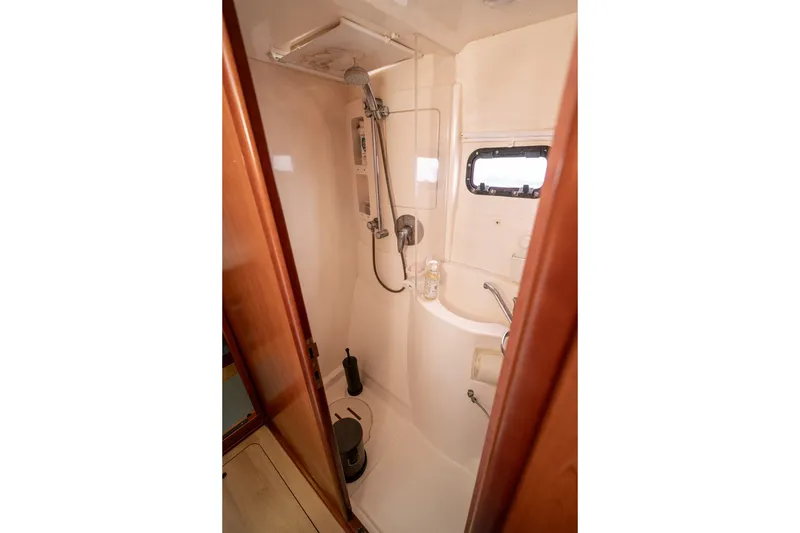 Slide: The Image of Compact bathroom in a 2011 Leopard 38 yacht with shower and porthole window. - 90