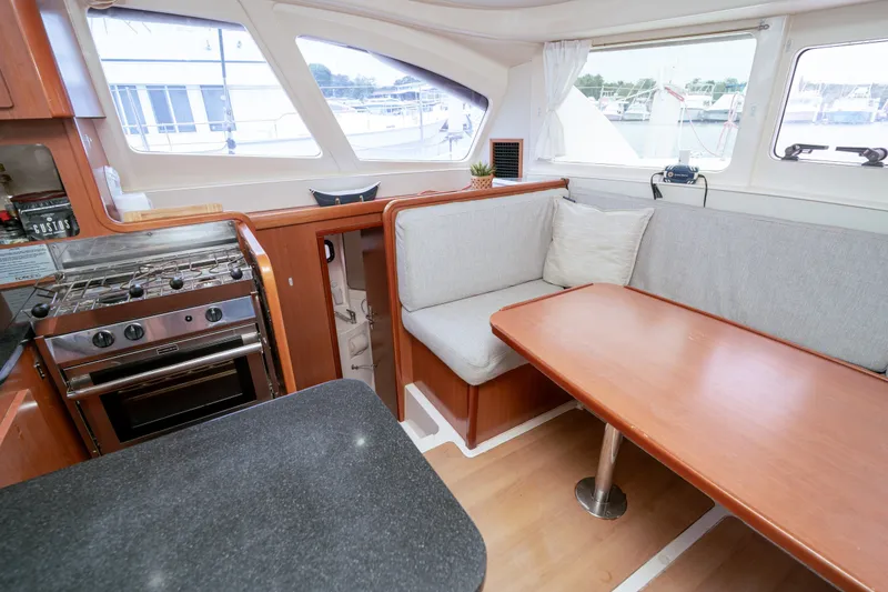 Slide: The Image of Interior of 2011 Leopard 38 yacht with kitchen and dining area, featuring wood finishes. - 139