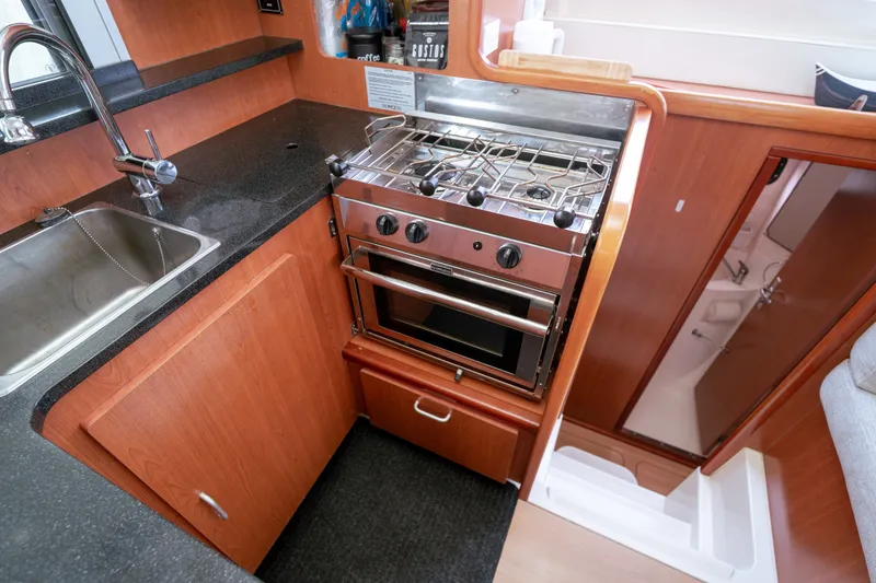 Slide: The Image of Compact kitchen area in a 2011 Leopard 38 yacht with stove and sink. - 133