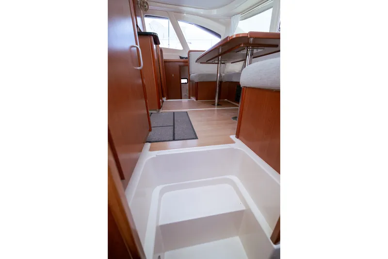 Slide: The Image of Interior of 2011 Leopard 38 catamaran, featuring wooden cabinetry and seating area. - 128