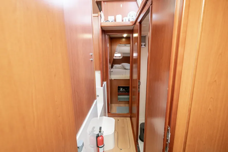 Slide: The Image of Narrow wooden hallway inside 2011 Leopard 38 yacht, featuring a compact cabin and storage. - 95