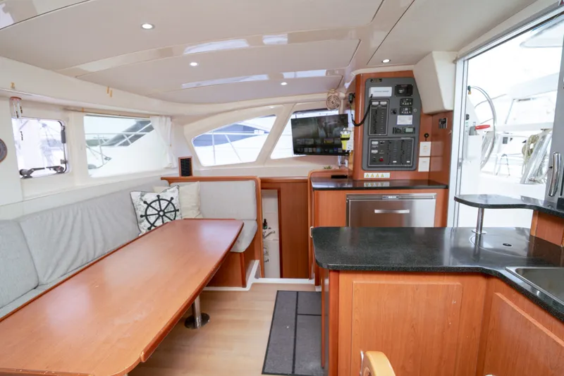 Slide: The Image of Interior of a 2011 Leopard 38 catamaran featuring a cozy dining area and modern kitchen. - 101