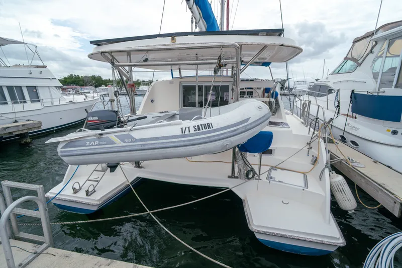 Slide: The Image of Leopard 38 catamaran from 2011 docked with dinghy, surrounded by other boats. - 10