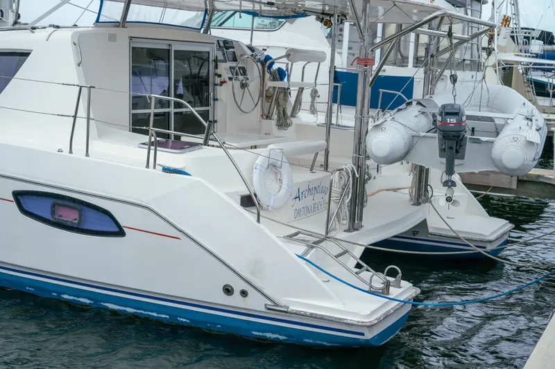 Slide: The Image of 2011 Leopard 38 catamaran docked with dinghy, featuring sleek design and spacious deck. - 71